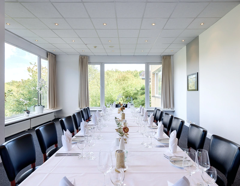 Tische mit Stühlen in einem Lichtdurchflutetem Raum